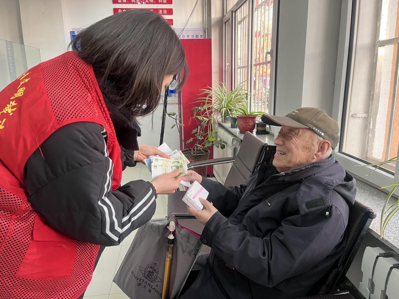 平庄东城街道红山路社区志愿者为高龄老人代购药品。（来源：元宝山区委宣传部）
