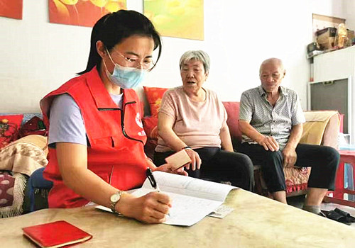 社区退役军人服务站工作人员上门为退役军人李国保办理优待证.