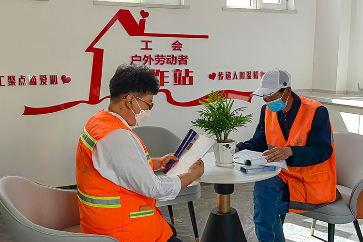 在工会户外劳动者服务站点休息看书的环卫工人.(摄影:张俊英)